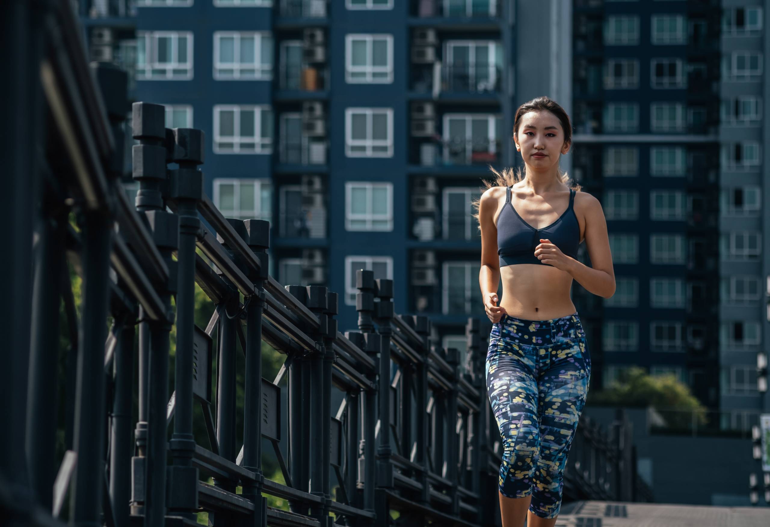 Woman running on city road with buildings in background