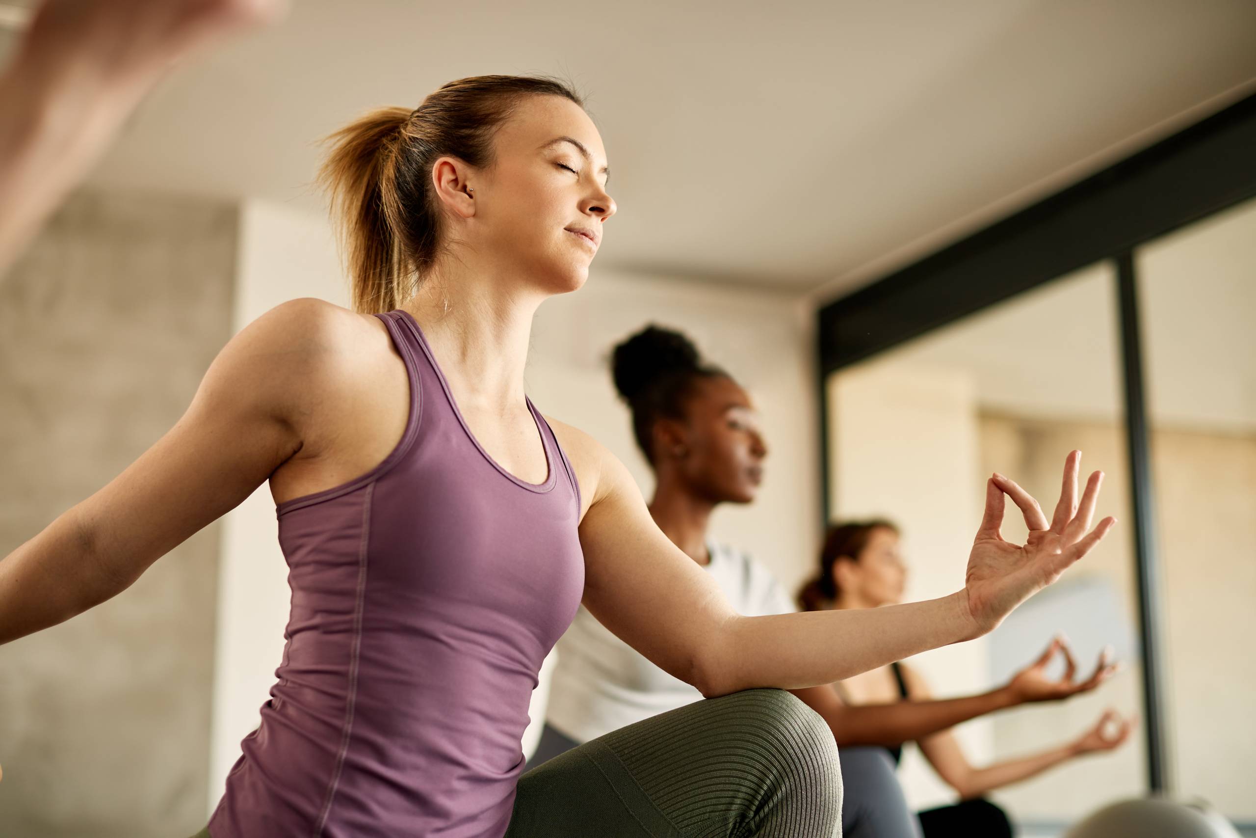 Below view of athletic woman doing relaxation exercise while working out at health club.