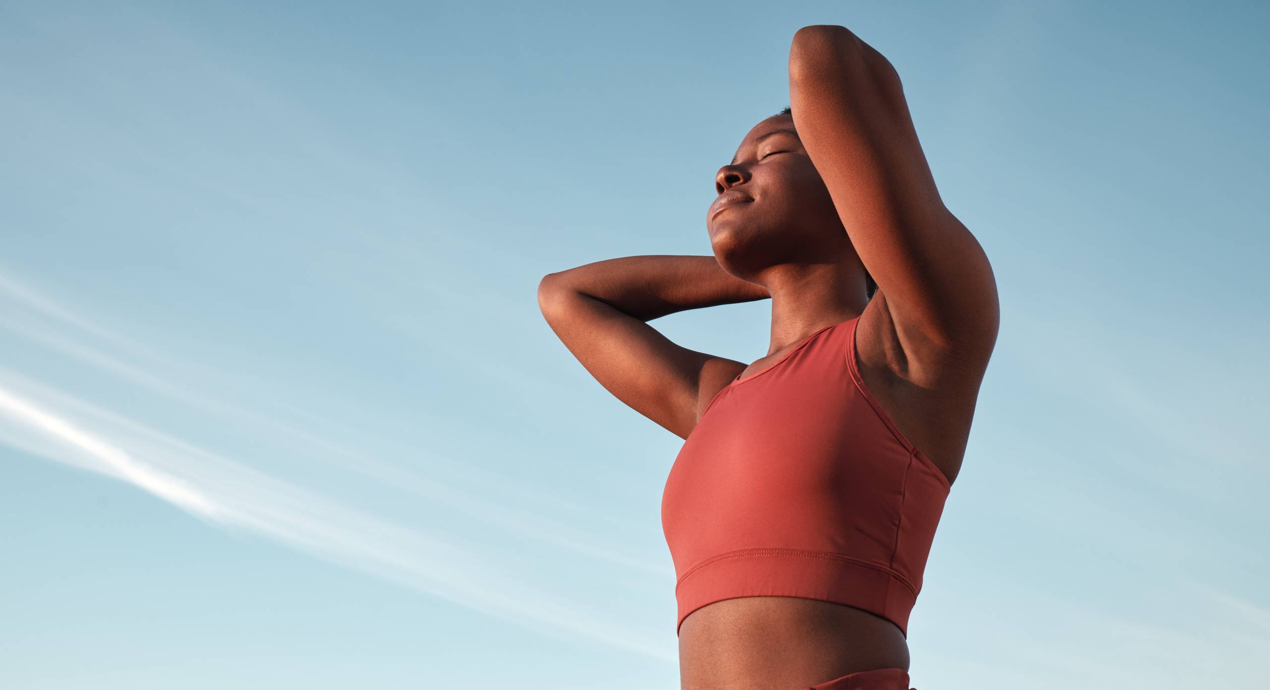 Freedom, fitness and black woman in nature for running, sports training and relax against a blue sky in South Africa. Wellness, peace and calm African runner with zen from an outdoor cardio workout