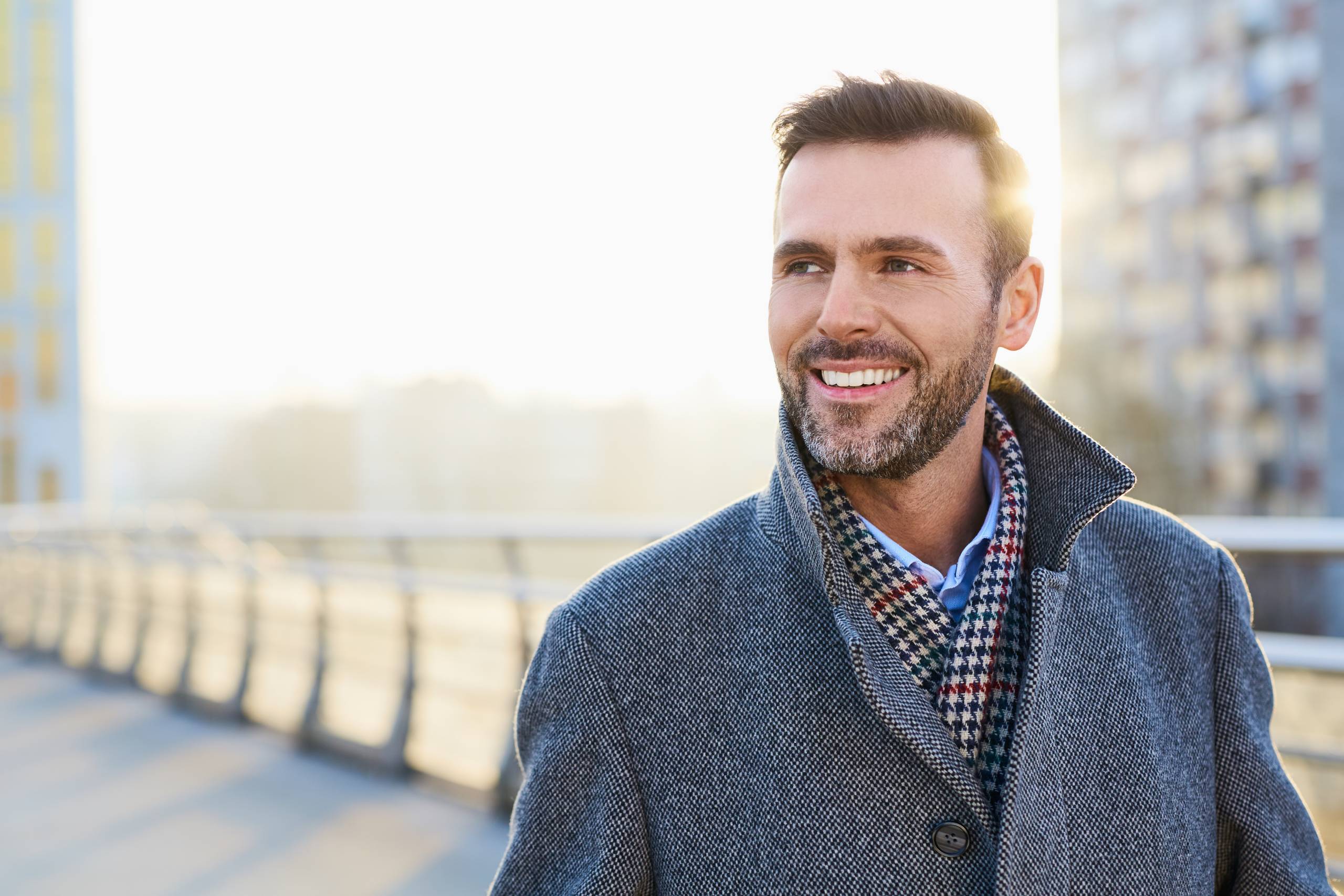 Happy man standing outdoors during sunny winter day